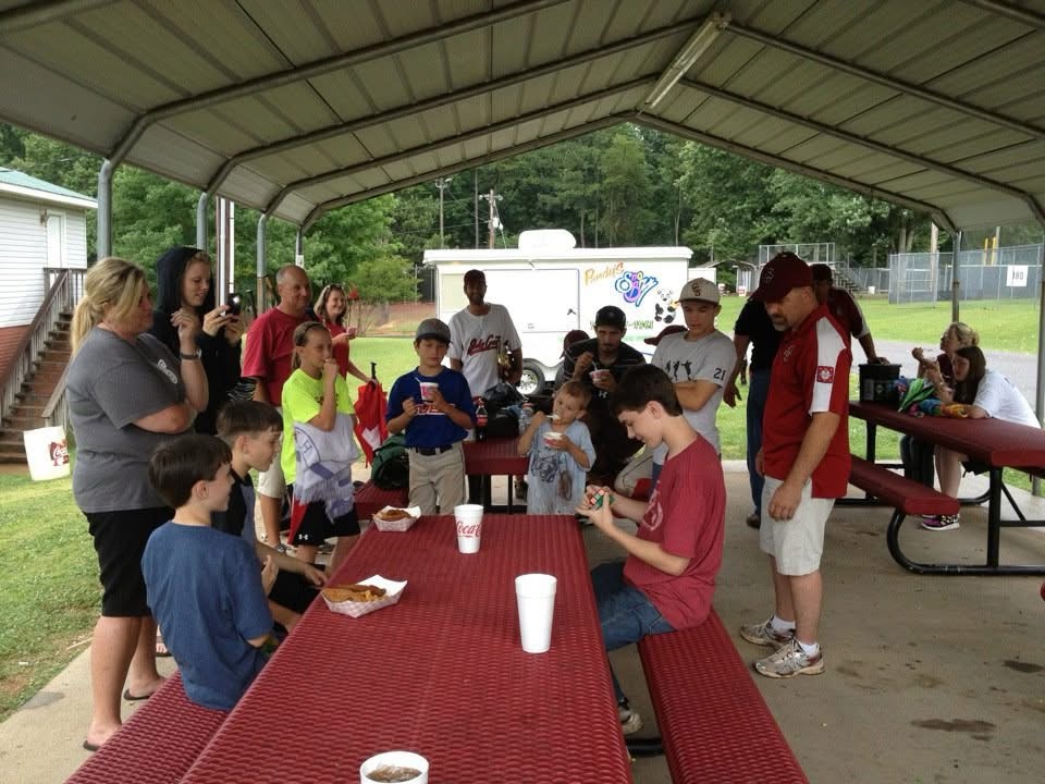 Young person speed-solving a Rubik's Cube while others gather to watch